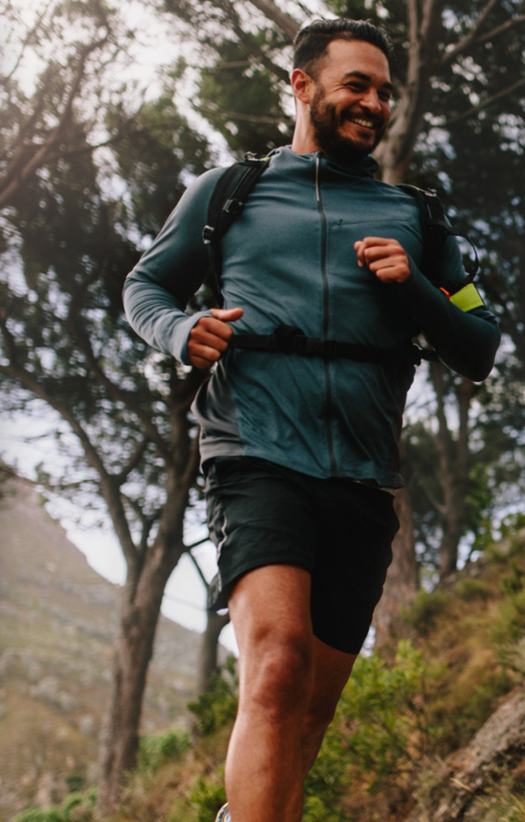 Man running outdoors with a backpack on a trail