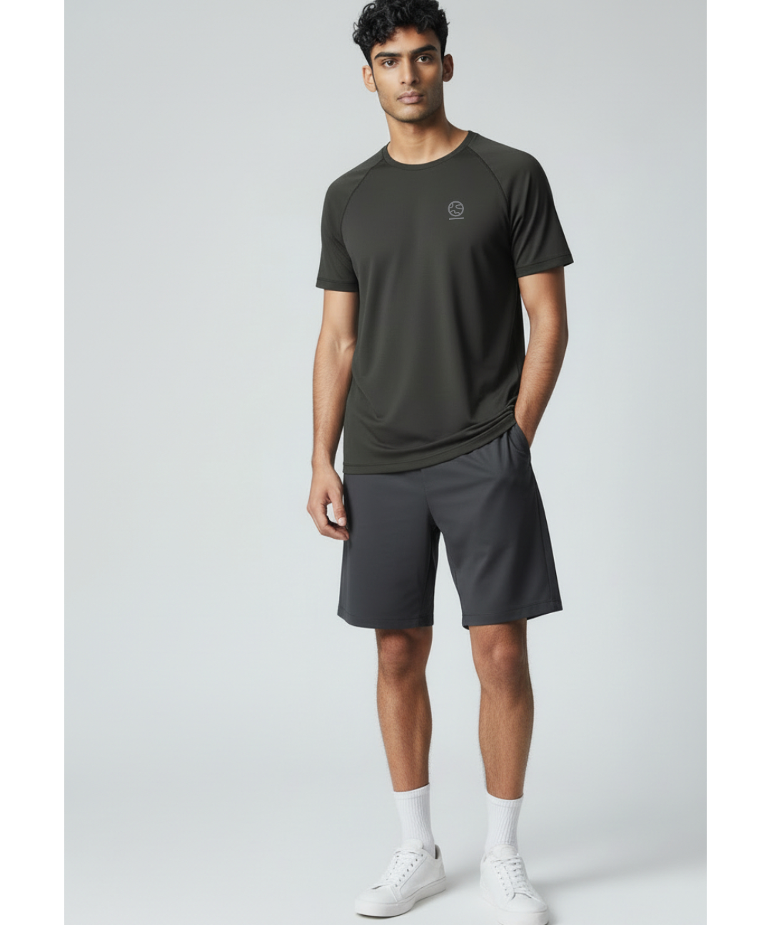 Man wearing a black underscored plastic-free t-shirt and grey shorts on a light gray background