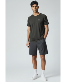 Man wearing a black underscored plastic-free t-shirt and grey shorts on a light gray background